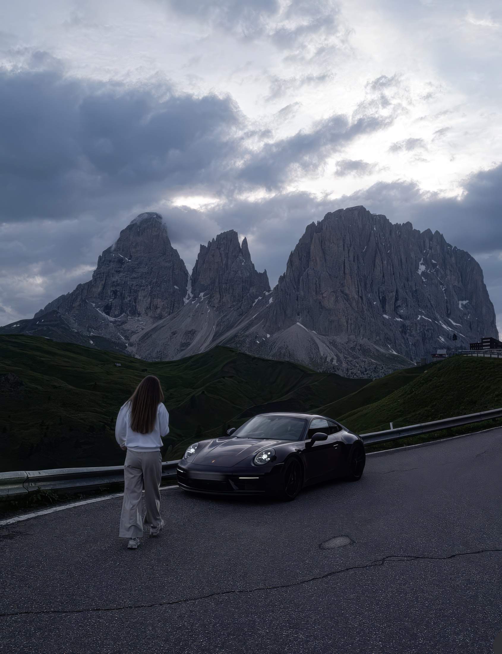 Creator standing beside a sports car in a mountain landscape with a motivational quote